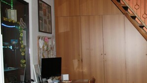 A room with a wooden desk, a computer, a chair, and a staircase. - Sole&Luna (Milazzo)