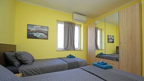 Una habitación con dos camas, un espejo grande y una ventana con cortinas.