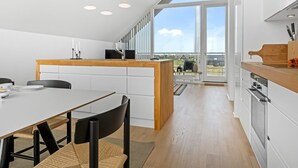 Eine moderne Küche mit einer Holztheke, weißen Schränken und einem großen Oberlicht.