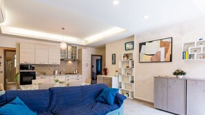 A modern living room with a sectional sofa, a kitchen with light-colored cabinets, and a dining area. - La dimora del pontile by Interhome (Ceriale)