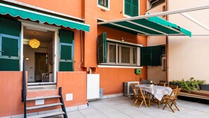 An outdoor patio with a table and chairs, a bench, and potted plants. - La dimora del pontile by Interhome (Ceriale)