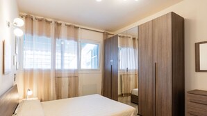 A bedroom with a bed, a wardrobe, a mirror, and a window with curtains. - La dimora del pontile by Interhome (Ceriale)