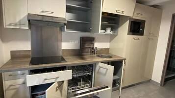 Een praktische keuken met een geïntegreerde vaatwasser, magnetron en een klein oven.