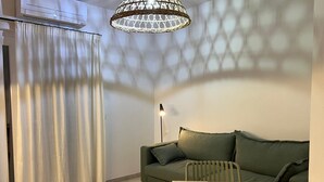 Una sala de estar moderna con un sofá verde, una mesa de madera y una lámpara de pie.