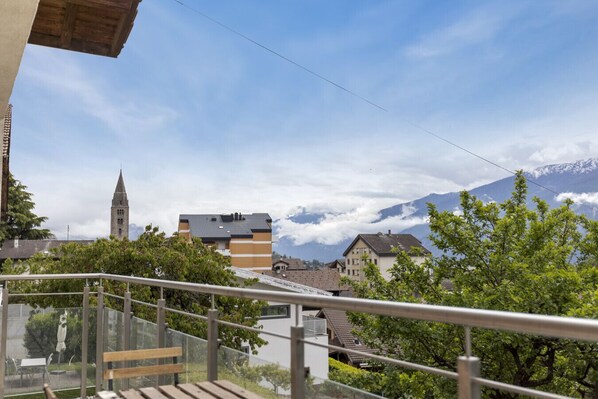 A balcony with a view of a town, a church tower, and mountains. - Beautifully renovated apartment with a view, in Savièse (Saint-Germain (Savièse)