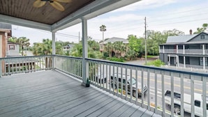 A covered porch with a ceiling fan, white railing, and a view of a street with parked cars and houses. - The Bold City Retreat #327 - Team Joseph Ellen (Jacksonville)