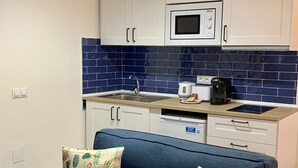 Una kitchenette compacta equipada con microondas, pileta y cafetera.