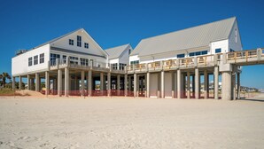 Un hotel frente a la playa con un amplio patio abierto, varios balcones y un paseo cubierto.