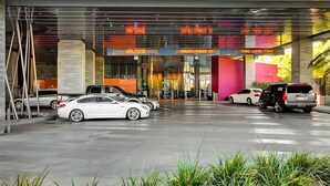 A modern hotel entrance with a glass facade, multiple parking spaces, and directional signage for valet, check-in, and taxi services. - One Bedroom | 1.5 Baths & Living Room | Jet Tub – Palms Place StripSuite- NO RESORT FEE (Las Vegas)