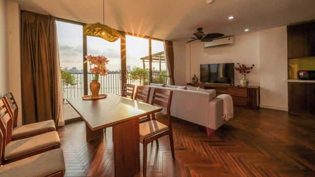 A modern living room with a dining area, large windows, a ceiling fan, and a TV. - Nine Housing West lake 136 Vu Mien (Hanoi)