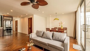 A modern living room with a grey sofa, wooden coffee table, and a ceiling fan. - Nine Housing West lake 136 Vu Mien (Hanoi)