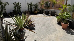 Terrassa a la teulada amb plantes en testos i un paviment de rajoles.