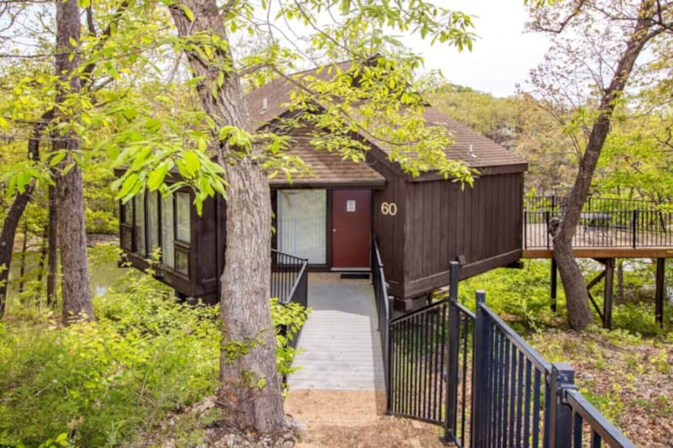 Een chalet met een houten gevel, een rode deur en een klein terras.