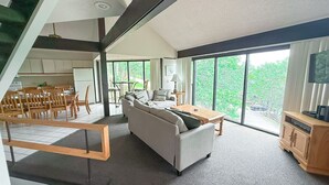 Uma sala de estar moderna com sofá, mesa de centro e área de jantar.