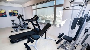 A gym with exercise equipment, large windows, and artwork on the walls. - Arun Haus 39 (Bangkok)
