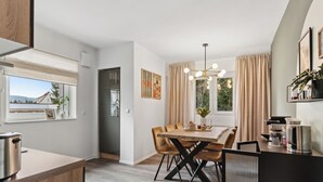 A modern kitchen with a dining area, featuring a wooden table, chairs, and a kitchen island.