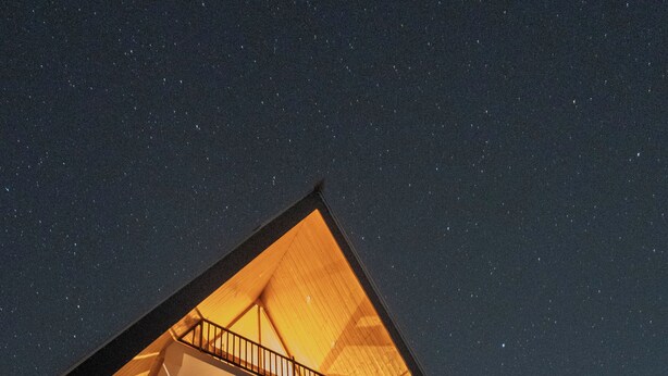 A modern two-story building with a sloped roof and a balcony on the upper floor. - Noni’s Dream Villa (Kullu)