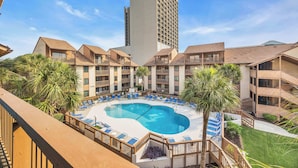 A hotel with a central pool, multiple balconies, and palm trees. - Anchorage by the Sea Ocean View Balconies and Pool (Myrtle Beach)