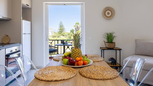 Una cocina con una mesa de comedor lista para una comida, un refrigerador y vistas al exterior.