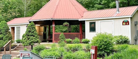 A small building with a red roof, a porch, and a sign indicating a spa.