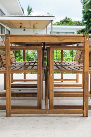 A wooden table with a central divider, surrounded by chairs.