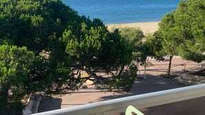 Une vue sur la côte, avec une plage de sable et de nombreux arbres verdoyants au premier plan.