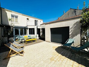 A courtyard with a patio, outdoor seating, and a garage. - Spacious 4-Bedroom House, Central Fouras, Near Beaches (Fouras)