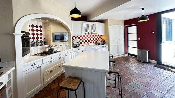 A modern kitchen with white cabinetry, a large island, and a checkered backsplash. - Spacious 4-Bedroom House, Central Fouras, Near Beaches (Fouras)