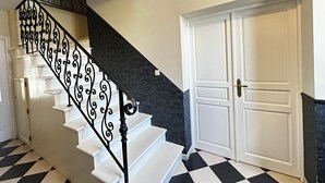A staircase with ornate black railings leading to a landing. - Spacious 4-Bedroom House, Central Fouras, Near Beaches (Fouras)