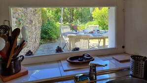 A kitchen with a large window overlooking a garden. - Charming fisherman's house, 4 pers, near beach, Saint-Gildas-de-Rhuys, wifi (Saint-Gildas-de-Rhuys)
