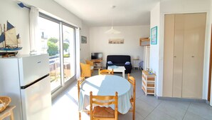Un espacio habitable compacto con cocina, comedor y una pequeña zona de estar.