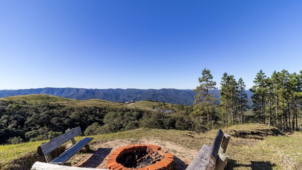 Un banco con vistas a un paisaje montañoso bajo un cielo despejado.