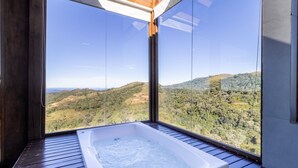 Una habitación con un ventanal grande con vistas a un paisaje montañoso.