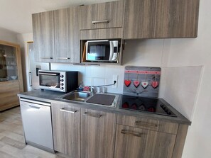 Cocina compacta equipada con microondas, tostadora y lavavajillas.
