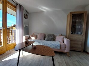 A living room with a sofa, a coffee table, and a wooden cabinet.