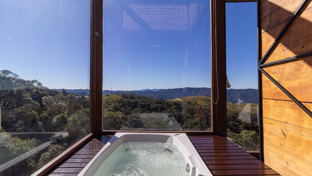 A hot tub with a view of a forested landscape and mountains. - Cabana romântica vista incrível VST002 (Anitápolis)