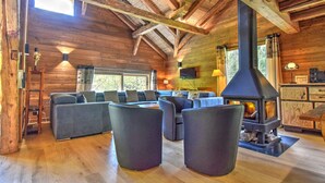 A log cabin interior with a large fireplace, wooden beams, and a cozy seating area. - Chalet for 16 with fireplace and pets allowed, near cable car in Morzine (Morzine)