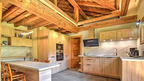 A kitchen with wooden cabinets, a marble countertop, and a built-in oven. - Chalet for 16 with fireplace and pets allowed, near cable car in Morzine (Morzine)