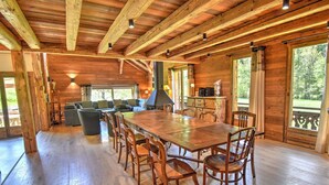 A spacious wooden cabin with a large dining table, multiple chairs, a sofa, and a fireplace. - Chalet for 16 with fireplace and pets allowed, near cable car in Morzine (Morzine)