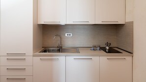 Eine moderne Küche mit Spüle aus Edelstahl, einer Kaffeemaschine und einem Toaster.