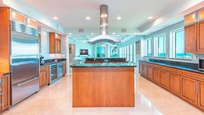 A spacious kitchen with a central island, stainless steel appliances, and wooden cabinetry.