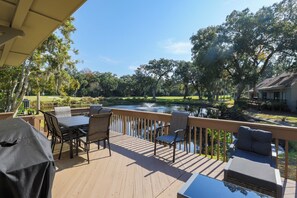 A wooden deck with outdoor furniture overlooking a pond and a golf course. - 721 Queens Grant: 3 Bedroom. 2.5 Bath Villa in Palmetto Dunes (Hilton Head Island)