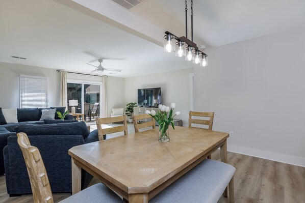 A dining area with a wooden table, chairs, and a vase of flowers. - 721 Queens Grant: 3 Bedroom. 2.5 Bath Villa in Palmetto Dunes (Hilton Head Island)