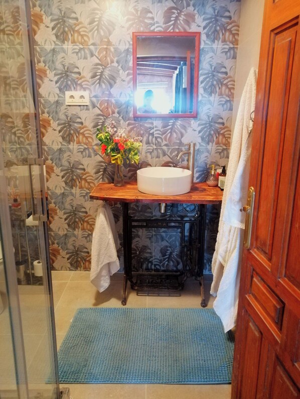 A bathroom with a sink, mirror, and shower. - Tropical oasis, rural Andalucía—tropical garden, huge pool, perfect for couples (Venta del Peral)