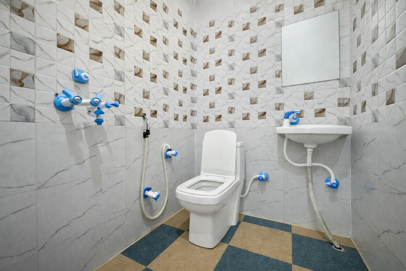 A bathroom with a toilet, a sink, and a shower with blue fixtures.