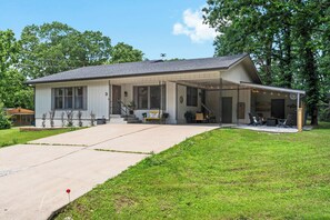 A single-story house with a covered porch, a front yard, and a driveway.