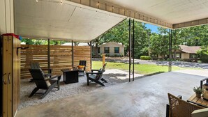 An outdoor patio area with a covered seating area, a fire pit, and a view of the surrounding neighborhood. - The Pedaler's Choice,  Minutes to MTB Trails (Bella Vista)