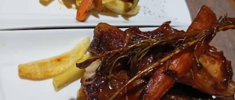 A plate of food with sliced meat, fries, and carrots.