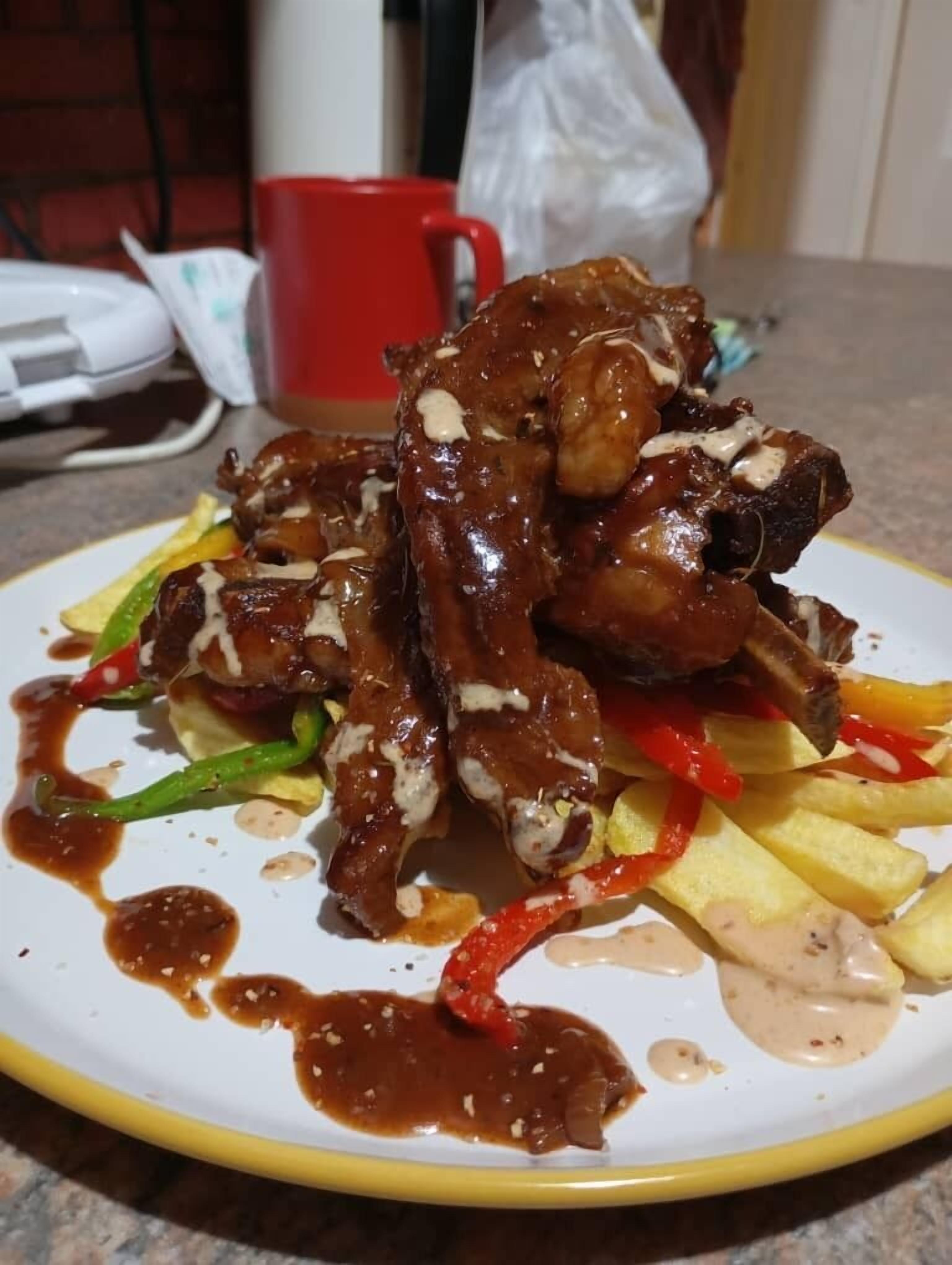 Un plato de comida con carne, verduras y salsa.