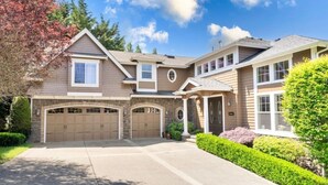 A two-story house with a garage, a covered entryway, and a well-maintained front yard. - 2BR Hideaway: Bar Vibes, Game & LEGO Joy @Bellevue (Bellevue)